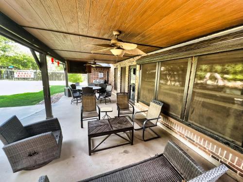 een overdekte veranda met stoelen en tafels en een plafond bij The Gotti Ranch in Weatherford