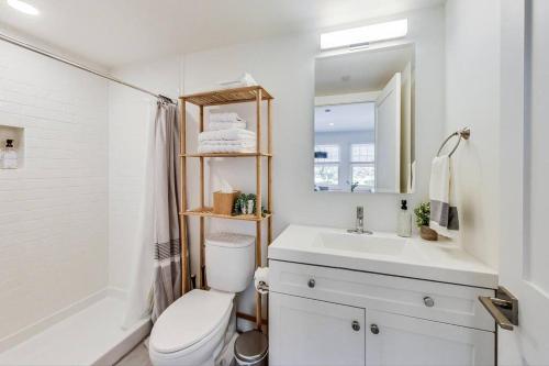 een witte badkamer met een toilet en een wastafel bij Private Luxury Studio in Lake Merritt in Oakland