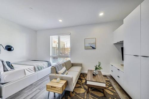 een witte woonkamer met een bank en een tafel bij Stylish Studio in Laney-Peralta in Oakland