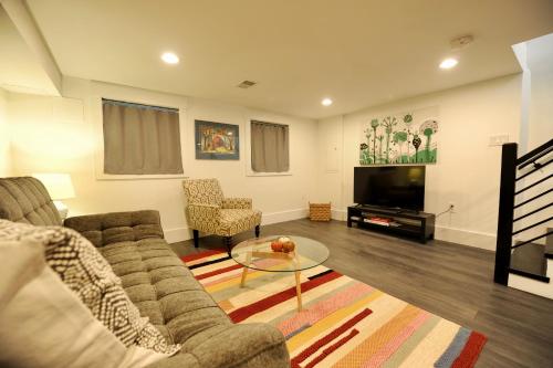 a living room with a couch and a television at Cherry Blossom Townhouse, Easy DC Access in Washington, D.C.