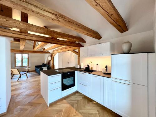 a kitchen with white appliances and wooden ceilings at Ferienzauber 1897 in Dornbirn