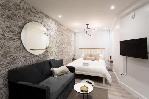 a bedroom with a bed and a couch and a mirror at 6768 - 102 Cozy and Fresh Mini Studio with kitchen by Denstays in Montréal