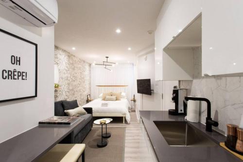 a room with a bed and a kitchen with a couch at 6768 - 102 Cozy and Fresh Mini Studio with kitchen by Denstays in Montréal