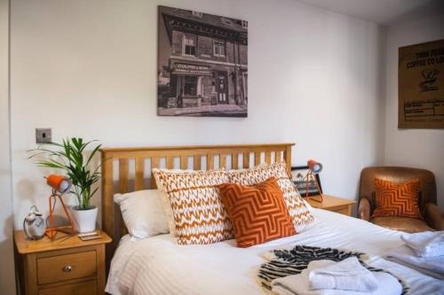 a bedroom with a bed with pillows and a picture on the wall at Sam's Place Apartment in Uppingham, Rutland in Uppingham