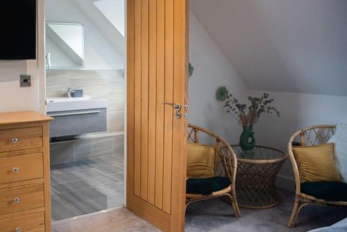 uma porta para um quarto com um lavatório e cadeiras em Sam's Place Apartment in Uppingham, Rutland em Uppingham
