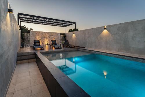 - une piscine dans une maison avec 2 chaises dans l'établissement Hotel Mexico, Merida, à Mérida