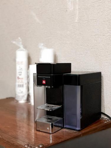 a black coffee maker sitting on a wooden table at Alaqur View Inn نزل واجهة العقر in Nizwa