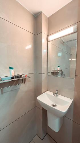 a white bathroom with a sink and a mirror at Kalloos Island Backwater Resort in Kollam