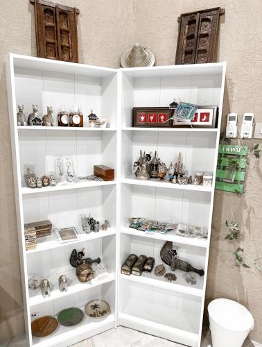 a white book shelf filled with lots of items at Alaqur View Inn نزل واجهة العقر in Nizwa