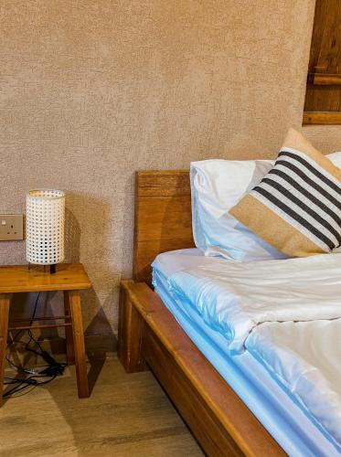 a bedroom with a bed and a table with a night stand at Alaqur View Inn نزل واجهة العقر in Nizwa