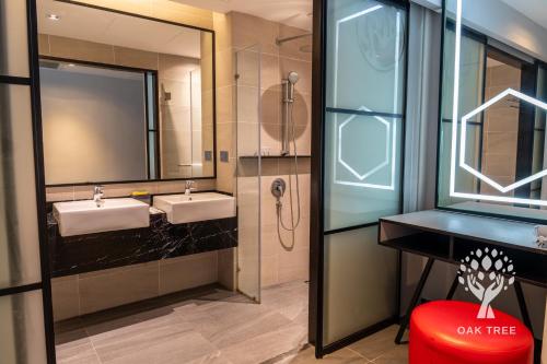 a bathroom with two sinks and two mirrors and a red stool at Red M101 by Oak Tree in Kuala Lumpur