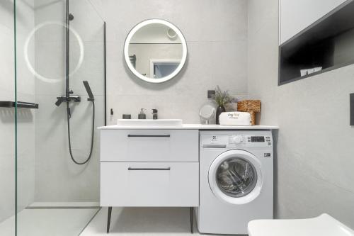 a white bathroom with a washing machine and a mirror at Nadmorski Apartament z ogródkiem przy plaży 114 Rezydencja Niechorze in Niechorze