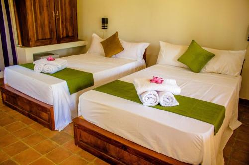 two beds in a room with towels on them at Tiara Elephant Lodge in Habarana