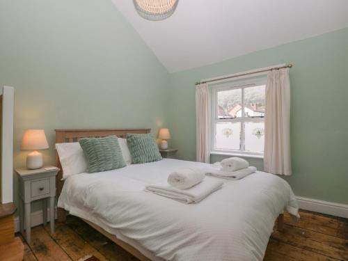 a bedroom with a bed with towels on it at Thyme Cottage in Great Malvern
