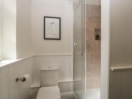 a bathroom with a toilet and a glass shower at Thyme Cottage in Great Malvern