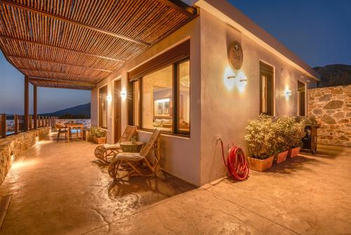 a porch of a house with chairs and a table at Sia Elafonisi Pool House in Elafonisi