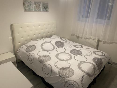 a bedroom with a bed with a white bedspread at Le Belvédère in Maîche