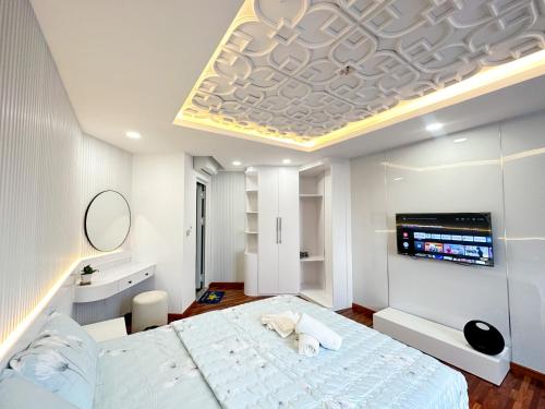 een slaapkamer met een groot wit bed en een televisie bij Phạm Viết Chánh-SSHOMES -1 PHÒNG NGỦ RIÊNG in Ho Chi Minh-stad