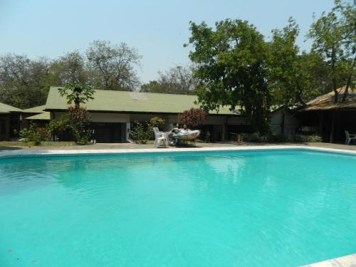 Dos personas sentadas en sillas junto a una piscina en The Landmark Boutique Hotel en Blantyre