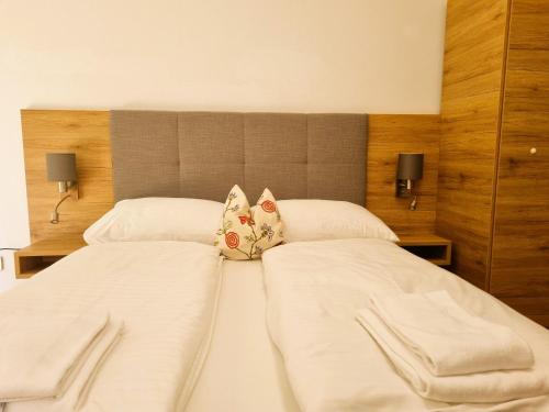 two beds in a bedroom with white sheets and pillows at Mountains and Lakes - Villa Gaumberg in Linz