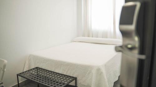 a small bed in a room with a window at Hotel Restaurante Boabdil in Otura