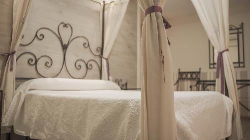 a bedroom with two beds with white sheets and a canopy at Hotel Restaurante Boabdil in Otura