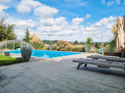 a backyard with a swimming pool and a bench at Mountains and Lakes - Villa Gaumberg in Linz