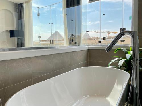 a bath tub in a bathroom with a window at Peace Inn West Pyramids Cairo in Cairo