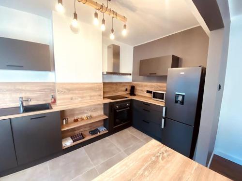 a large kitchen with a refrigerator and a sink at Appartement en centre-ville in Saint-Avold