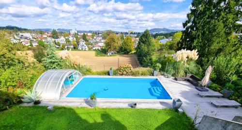 - une vue sur la piscine dans le jardin dans l'établissement Mountains and Lakes - Villa Gaumberg, à Linz