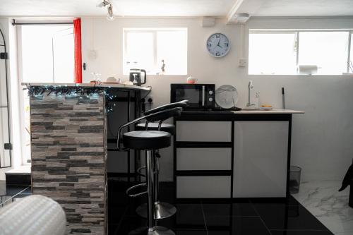 a kitchen with a counter and a bar stool at Studio B in Port Louis