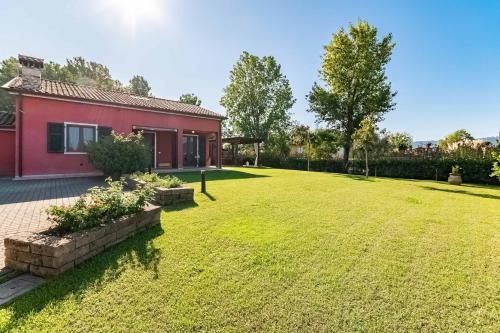 a large yard with a red house with a garden at Villa Luxury - Sarzana in Luni