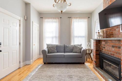 a living room with a couch and a fireplace at The Matisse at Wooster Square Yale with Parking in New Haven