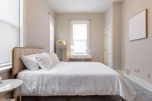 een slaapkamer met een wit bed en een raam bij The Matisse at Wooster Square Yale with Parking in New Haven