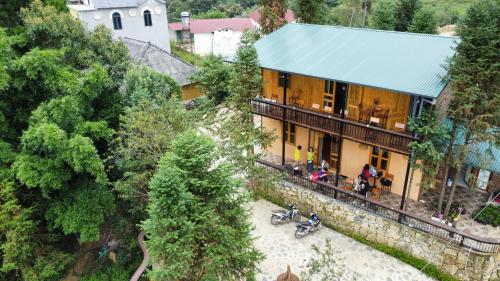 an overhead view of a yellow building with a blue roof at THEN'S HOUSE Y TÝ in Phan Kơng Su