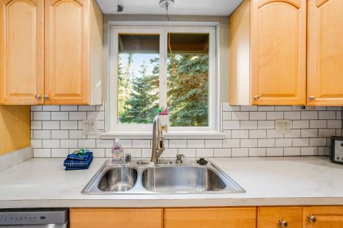 uma cozinha com um lavatório e uma janela em Eagle River Getaway em Eagle River