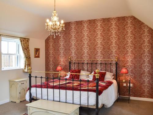 una camera con letto e lampadario a braccio di The Parlour a Ferndown