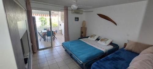 a bedroom with a bed and a couch and a patio at Studio de l'Anse Mitan, Domaine des Tuileries in Les Trois-Îlets