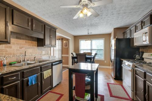 a kitchen with wooden cabinets and a black refrigerator at Atlanta Retreat with 2-Car Garage, Fenced Yard home in Locust Grove