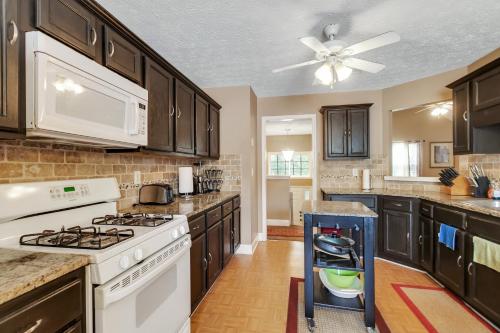 a kitchen with white appliances and a ceiling fan at Atlanta Retreat with 2-Car Garage, Fenced Yard home in Locust Grove