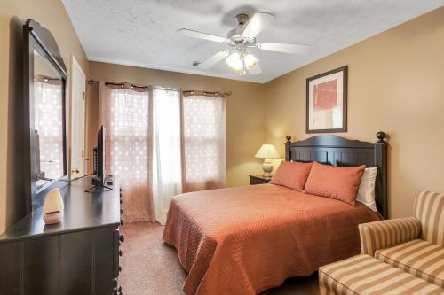 a bedroom with a bed and a television and a chair at Atlanta Retreat with 2-Car Garage, Fenced Yard home in Locust Grove