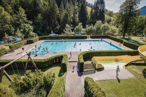 een groot zwembad met mensen erin bij Ferienhaus am Mühlbach in Gams bei Hieflau