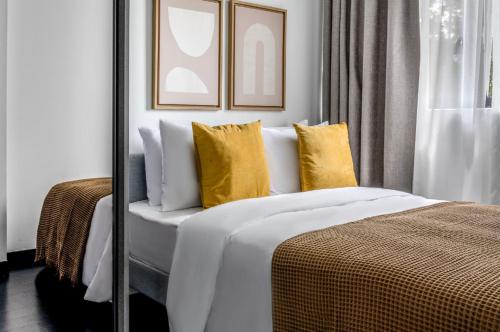新加坡的住宿－2Bedroom apartment near Orchard RD!，一间卧室配有一张带黄色枕头的大床