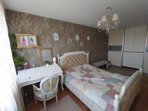 a bedroom with a bed and a dresser and a desk at Provence apartment in Šiauliai