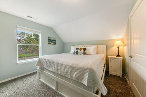 a bedroom with a white bed and a window at Seaside Treasure in Seaside