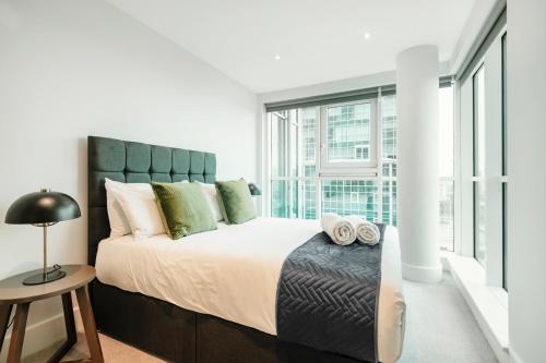 Un dormitorio con una cama grande y una ventana en Vauxhall Skyline Apartment, en Londres