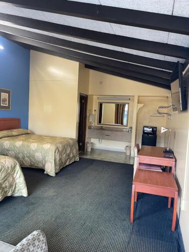 a hotel room with two beds and a desk at Budget Inn - Madison in Madison