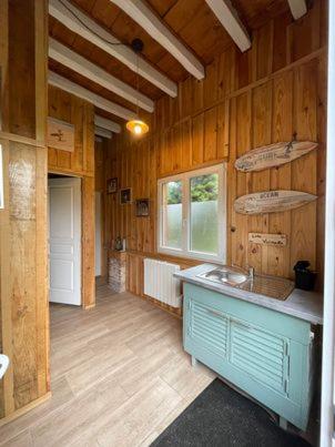 - une cuisine avec des murs en bois et un comptoir dans la chambre dans l'établissement Gîte familial en pleine nature- Domaine Temali, à Labouheyre