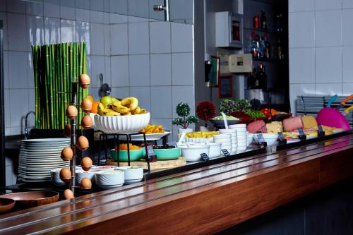 una línea de buffet con cuencos de frutas y otros alimentos en Ibis Styles Abidjan Marcory en Abiyán