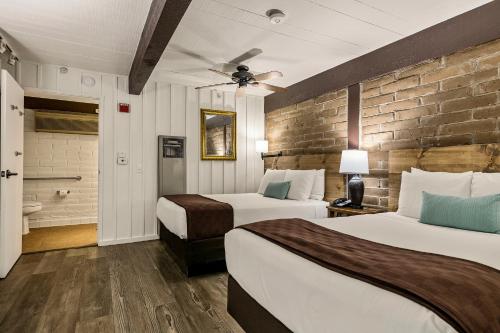 a hotel room with two beds and a brick wall at El Pueblo Inn in Sonoma